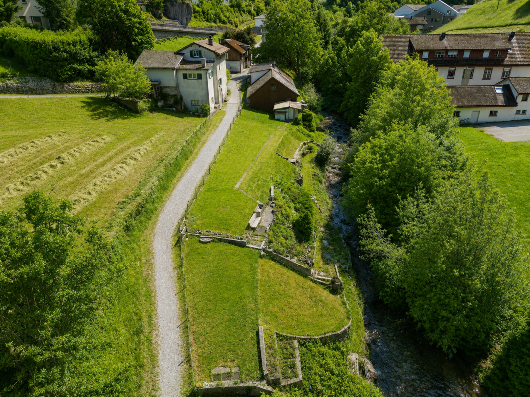 Luftaufnahme eines ländlichen Grundstücks mit Häusern und Bachlauf
