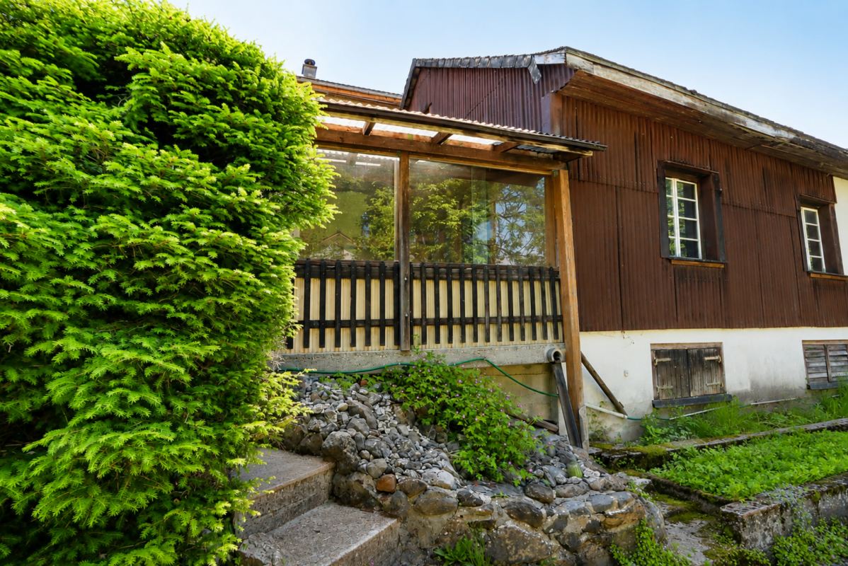 Holzfassade mit verglastem Anbau und Gartenblick