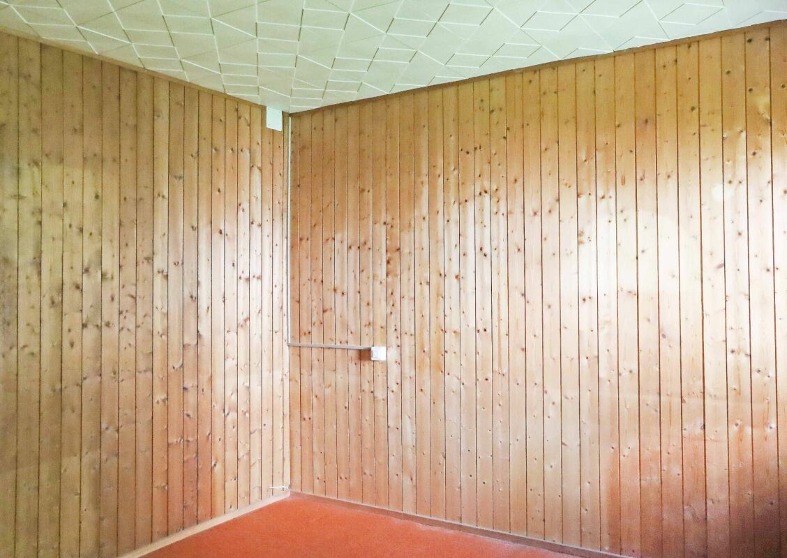 Holzvertäfelter Raum mit rotem Boden