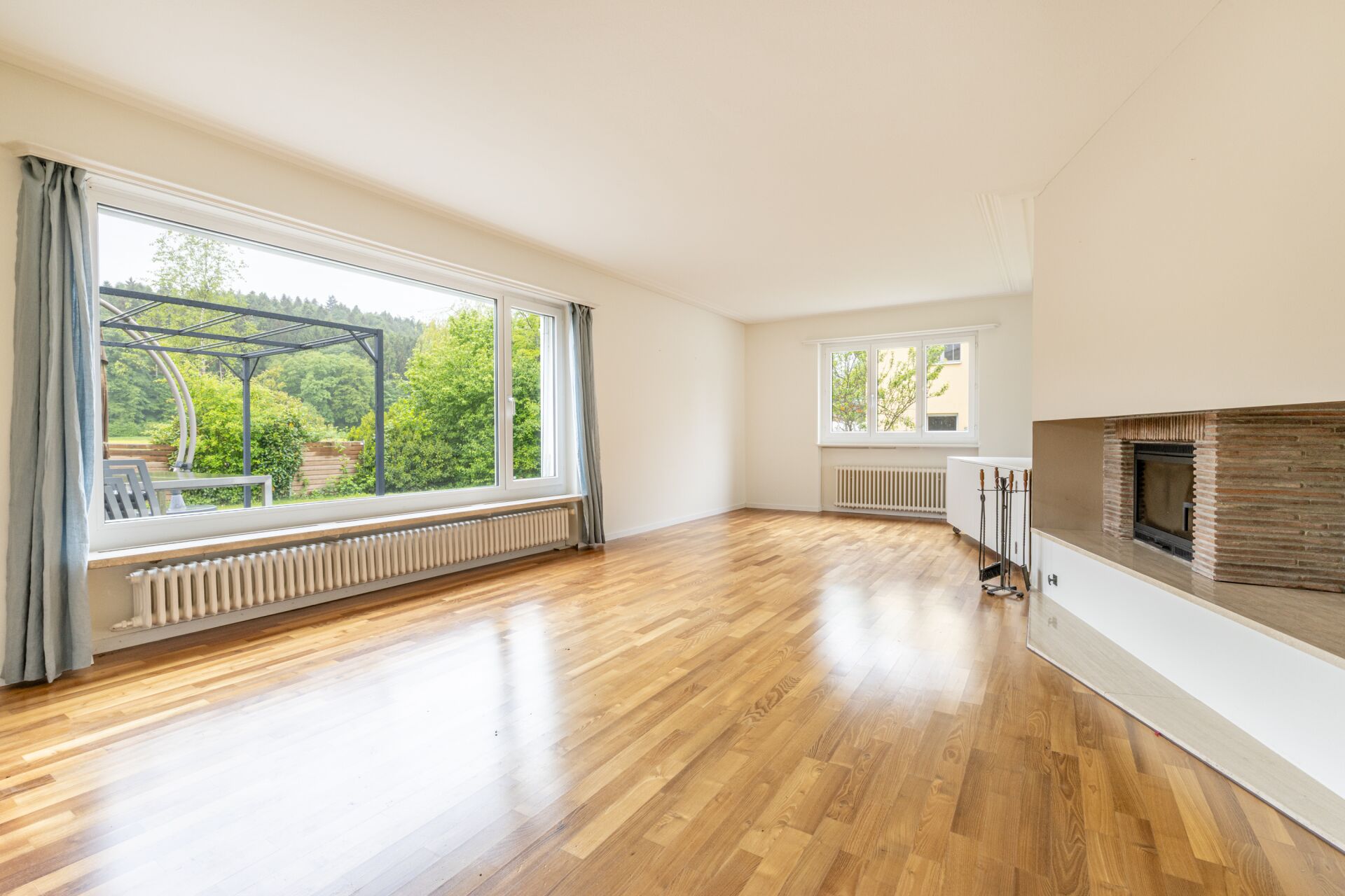 Heller Wohnraum mit Kamin und Gartenblick