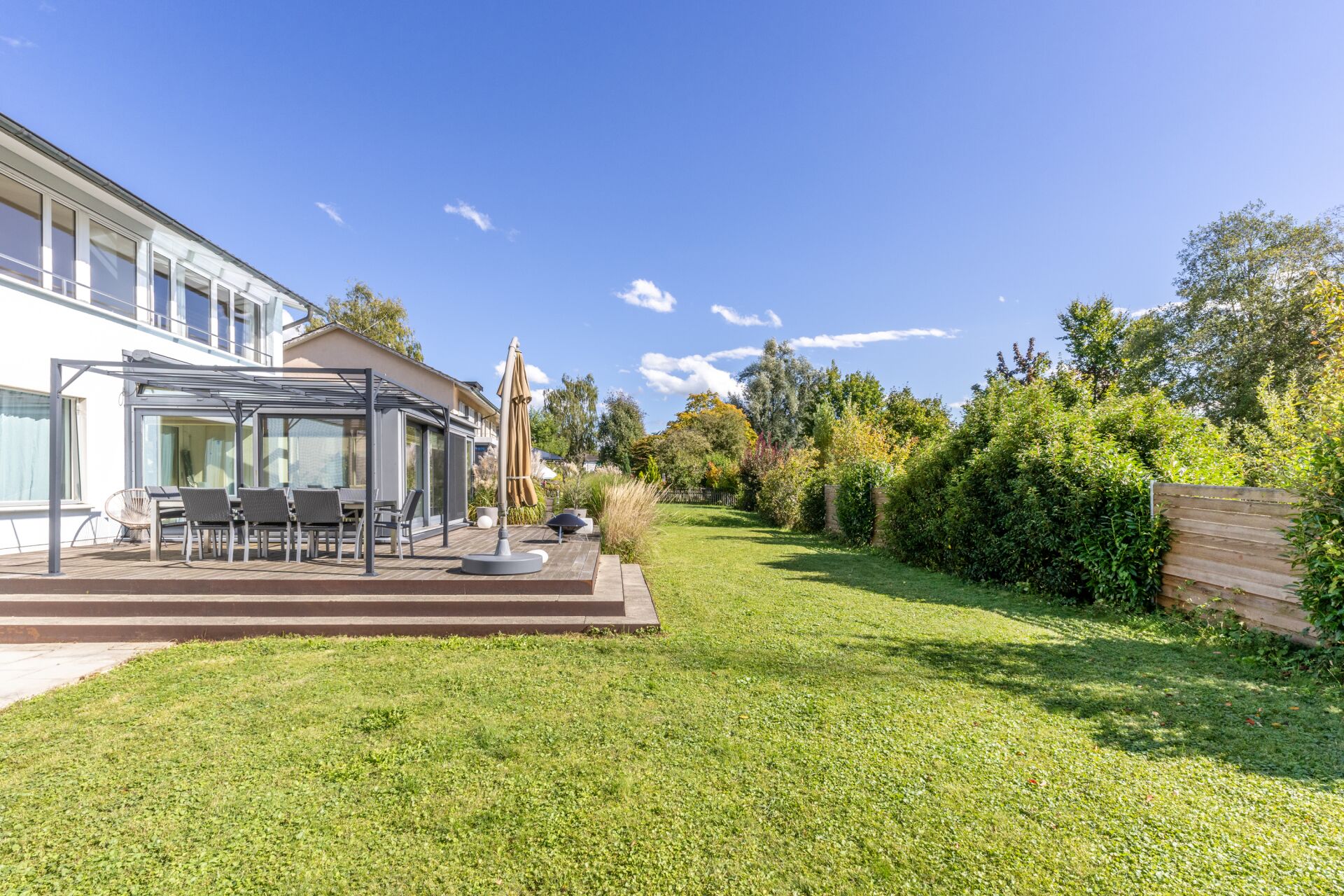 Garten mit Terrasse und Hausfassade