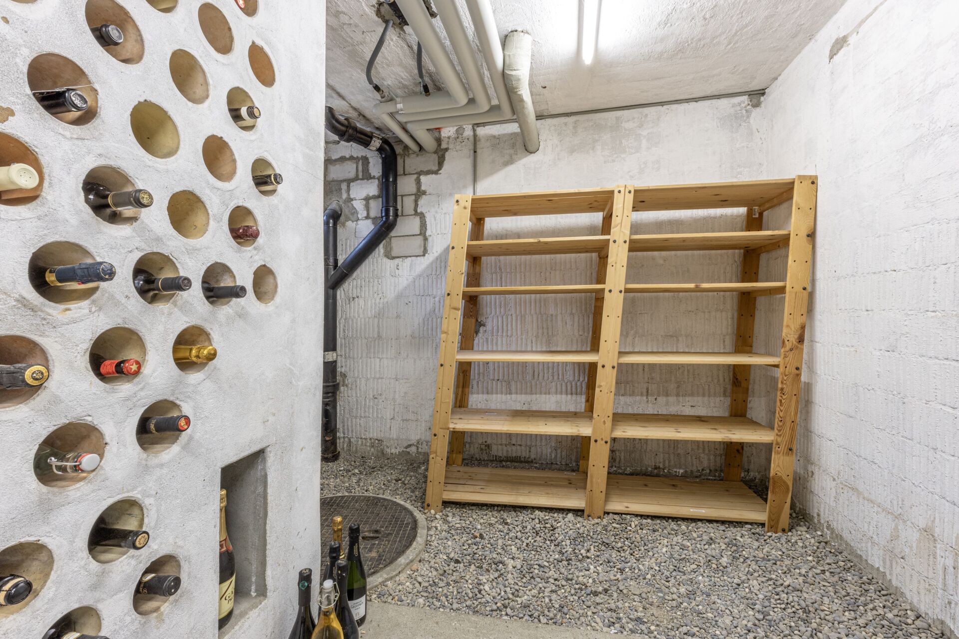 Weinkeller mit Flaschenwand und Holzregalen