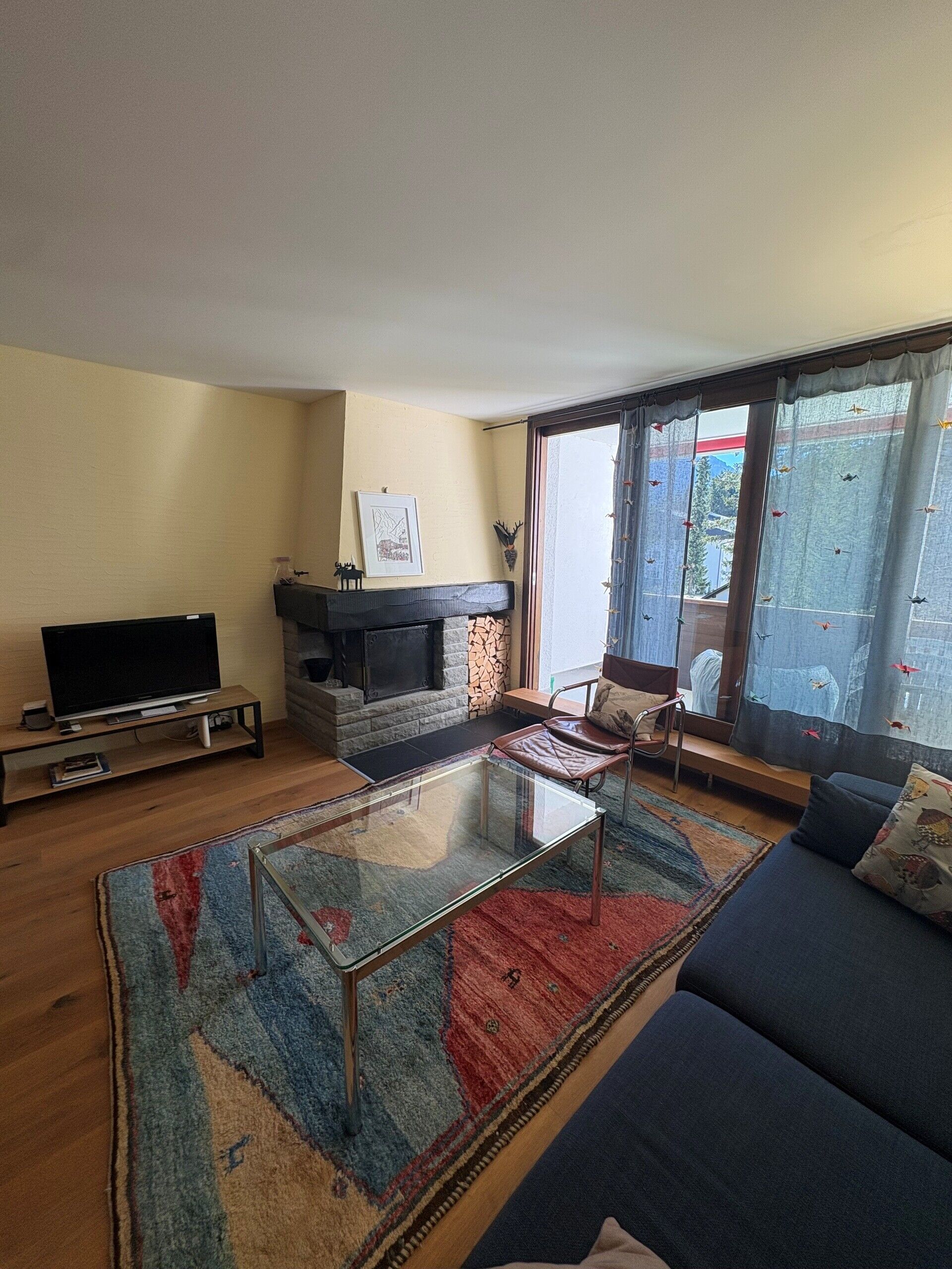 Wohnzimmer mit Kamin und Balkonblick
