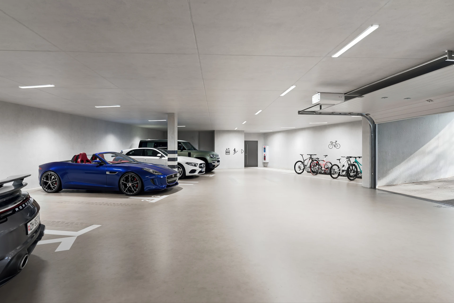 Moderne Tiefgarage mit Sportwagen und Fahrrädern