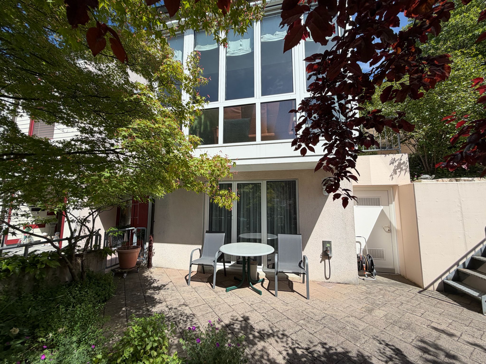 Terrasse mit Sitzbereich vor moderner Fassade