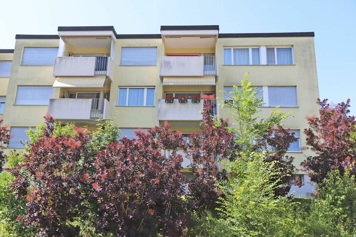 Mehrfamilienhaus mit Balkonen und Grünanlage