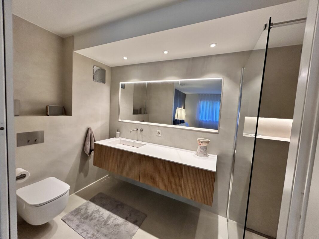Modernes Badezimmer mit Waschtisch, Spiegel und Dusche