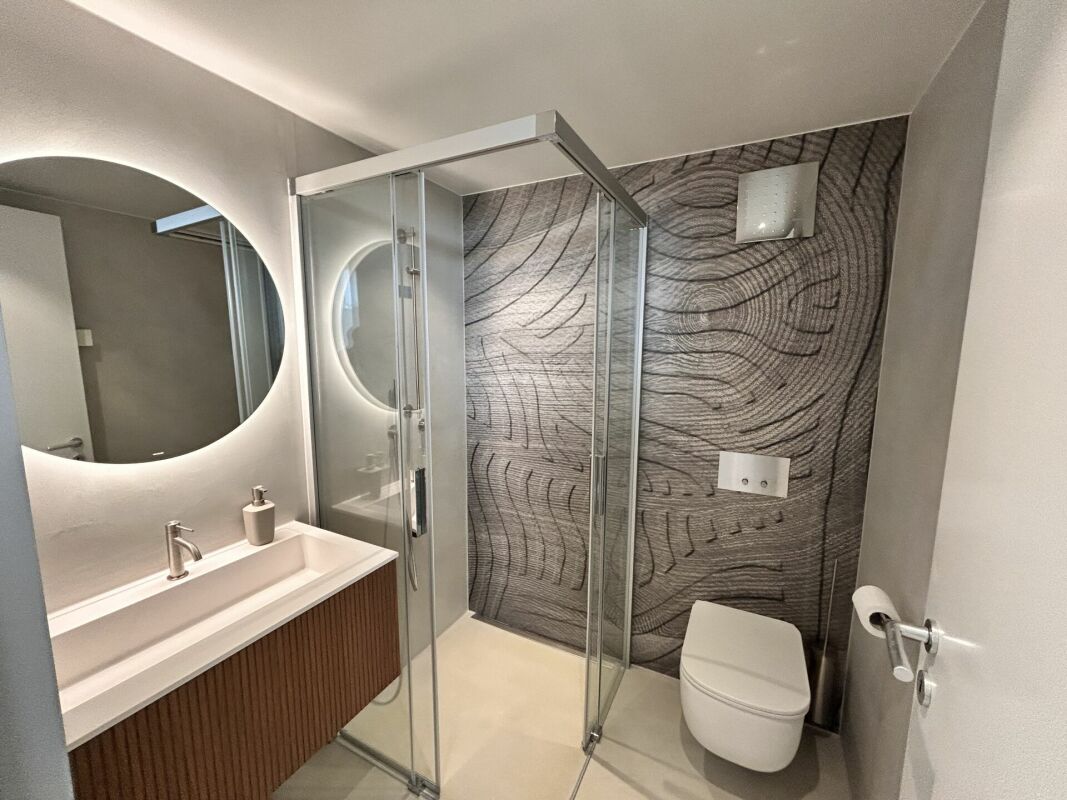 Modernes Badezimmer mit runder Spiegelbeleuchtung