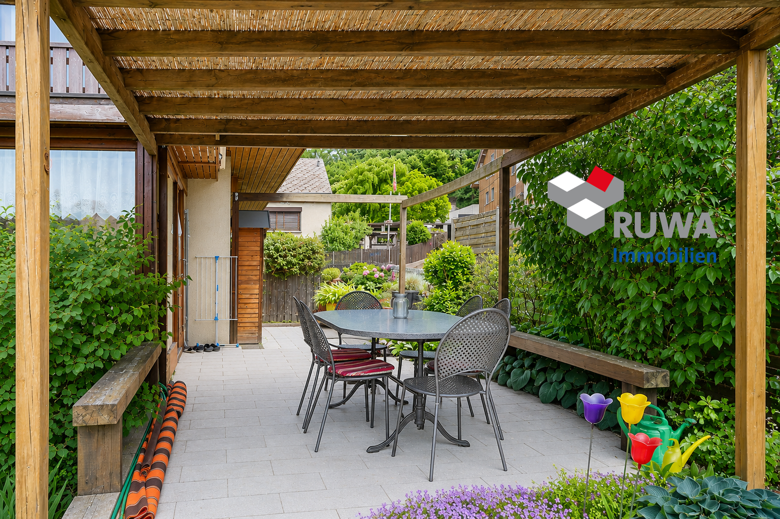 Überdachte Terrasse mit Sitzgruppe und Gartenblick