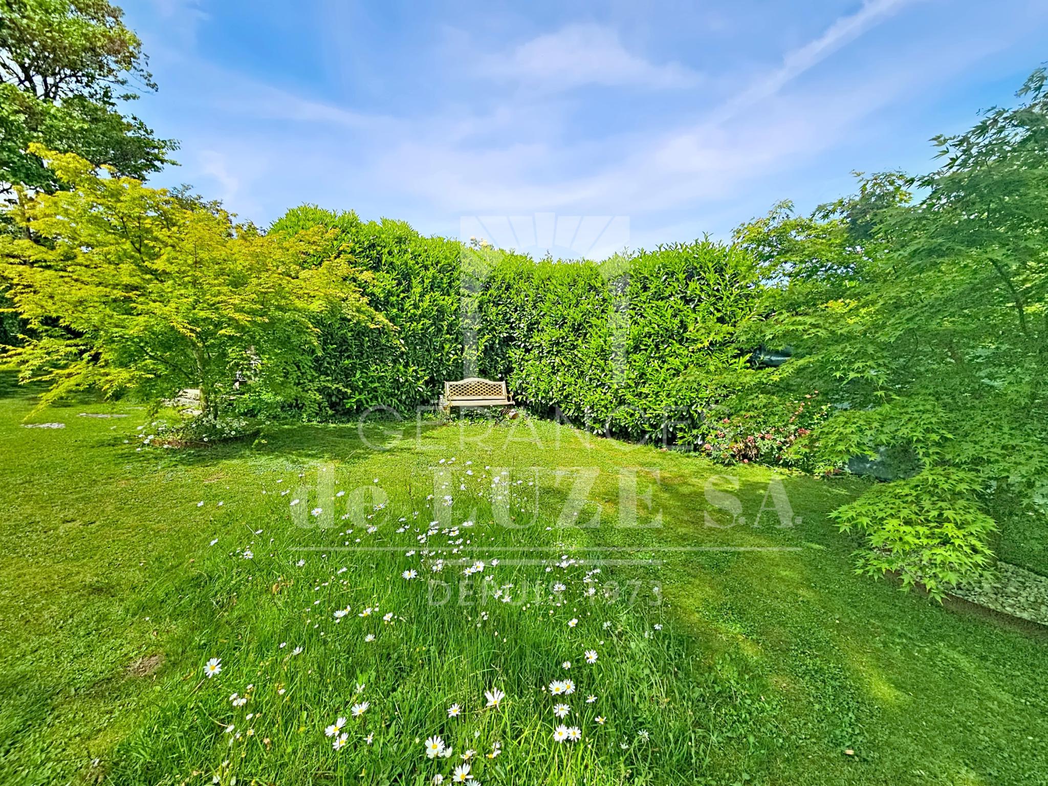 Garten mit gepflegter Rasenfläche und Sitzbank