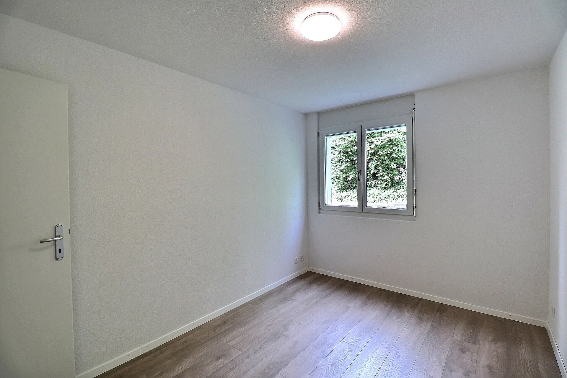 Helles, leeres Zimmer mit Fenster