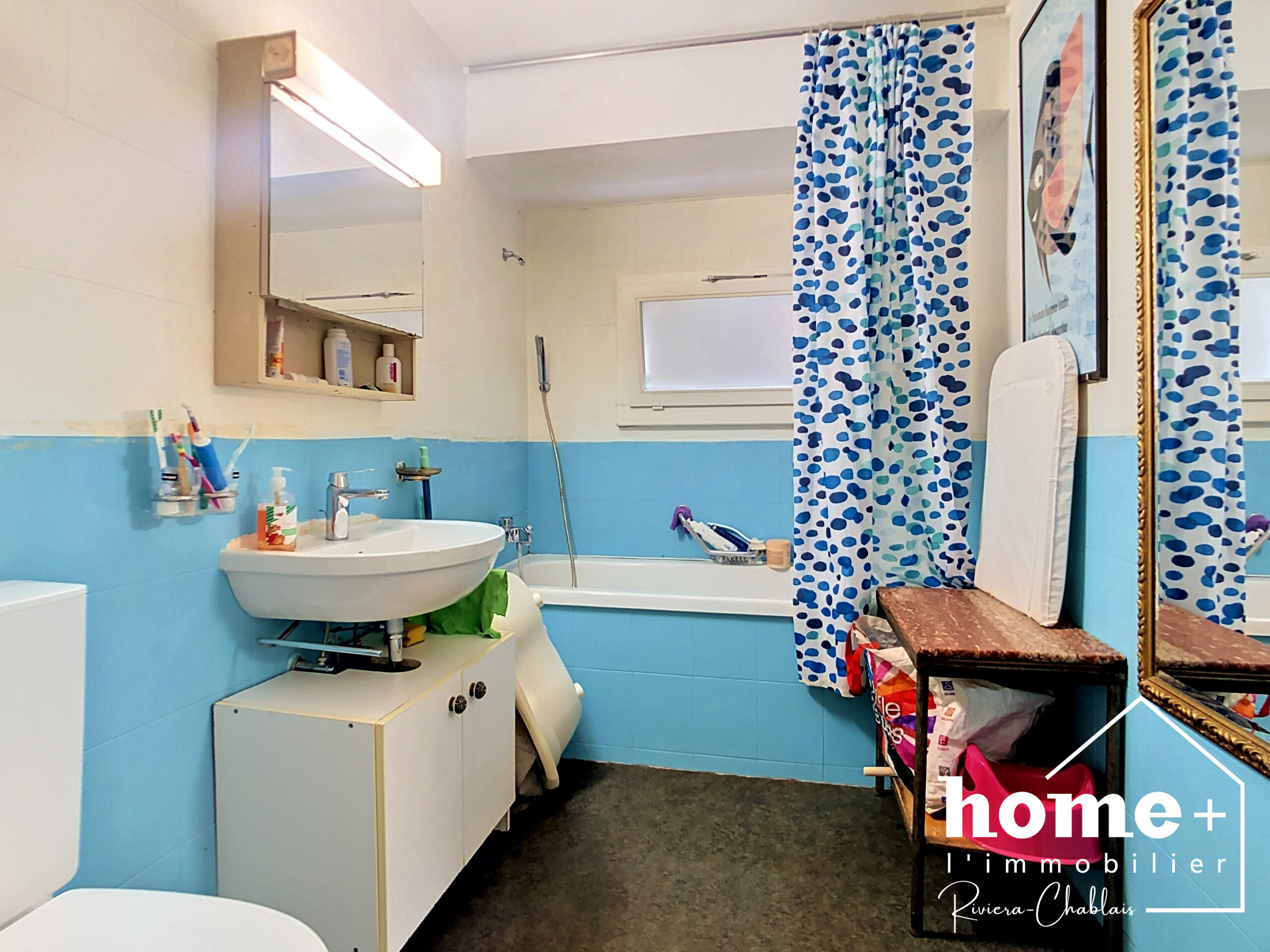 Kleines Badezimmer mit Badewanne und Waschplatz