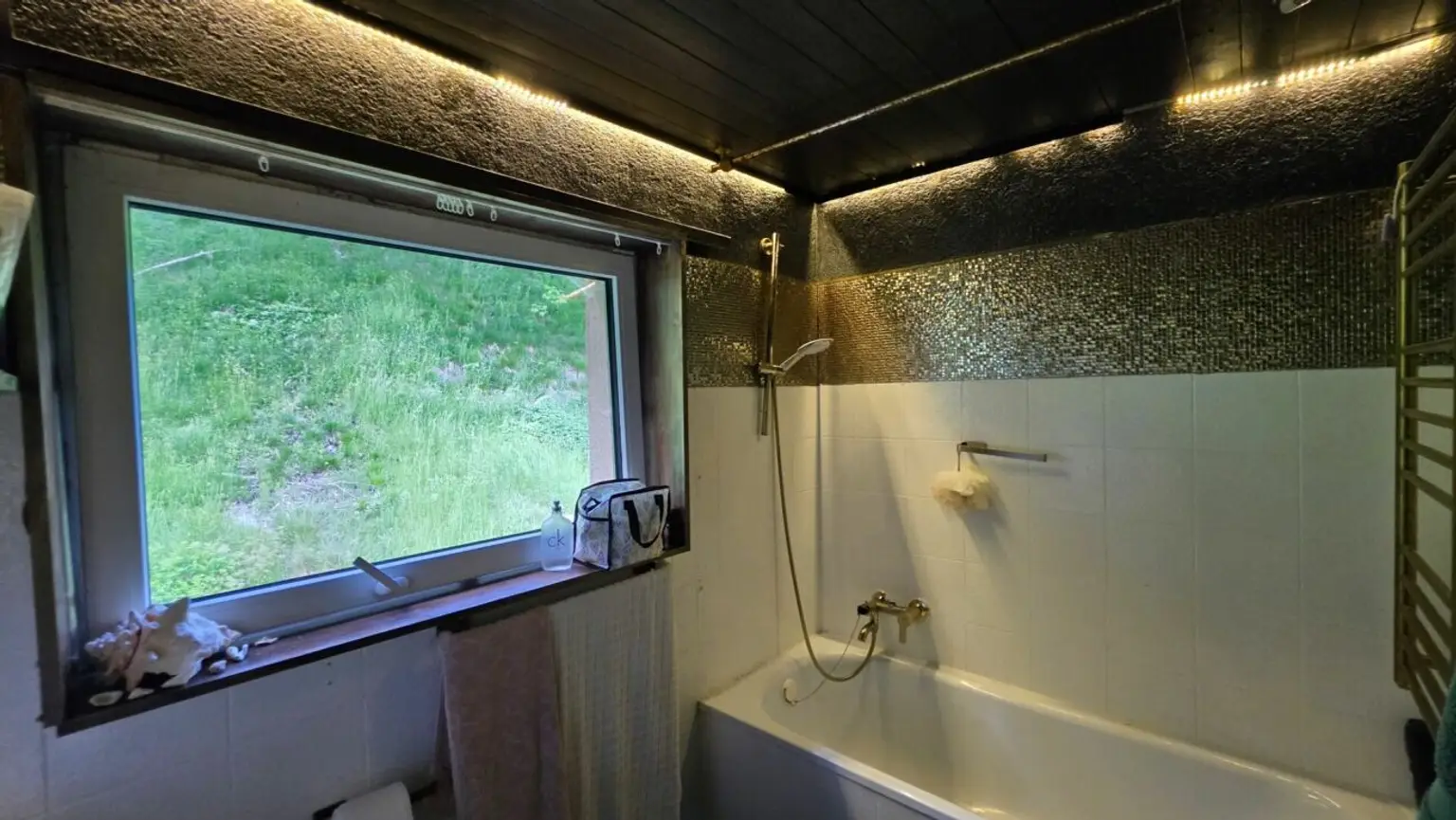 Modernes Badezimmer mit Badewanne und großer Fensteröffnung