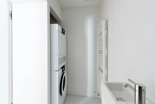 Hauswirtschaftsraum mit Waschmaschine und Handwaschbecken