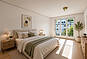 Helles Schlafzimmer mit zwei Betten und Blumenfenster