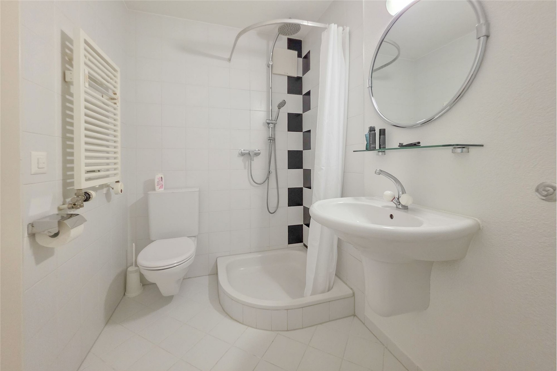 Kompaktes weißes Badezimmer mit Dusche und WC