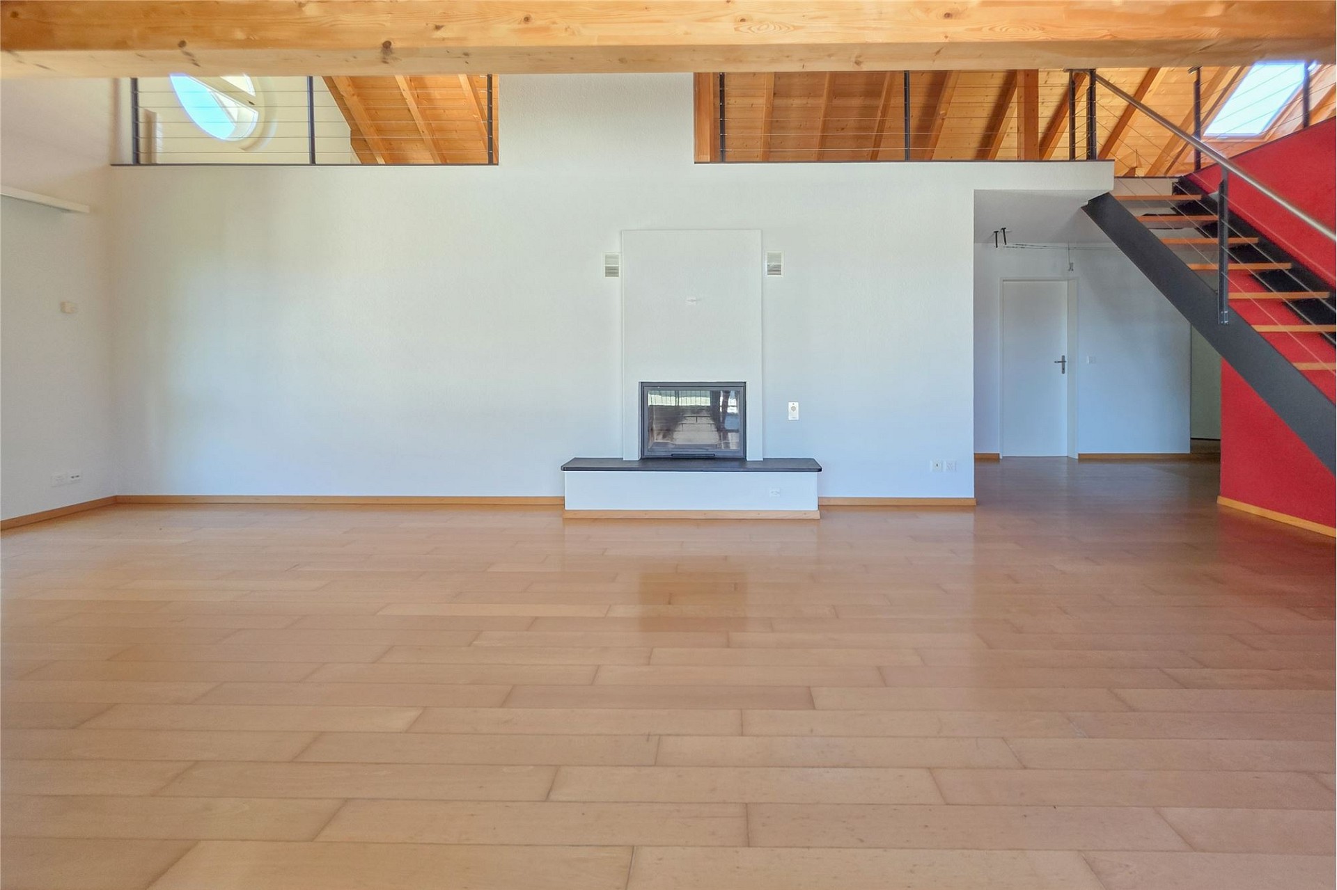 Offener Wohnraum mit Kamin und Treppe