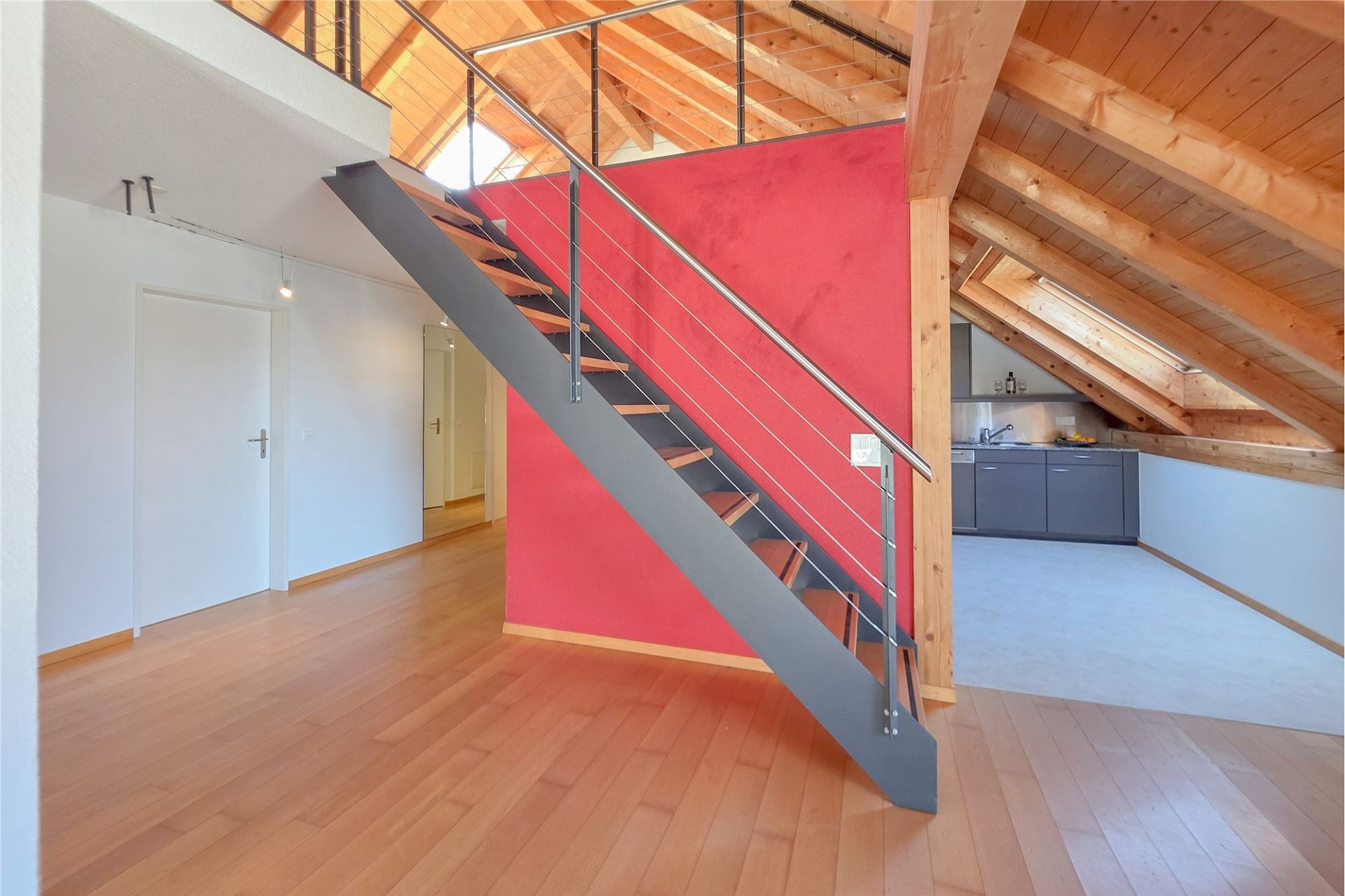 Dachgeschoss-Wohnraum mit Treppe und Küchenbereich