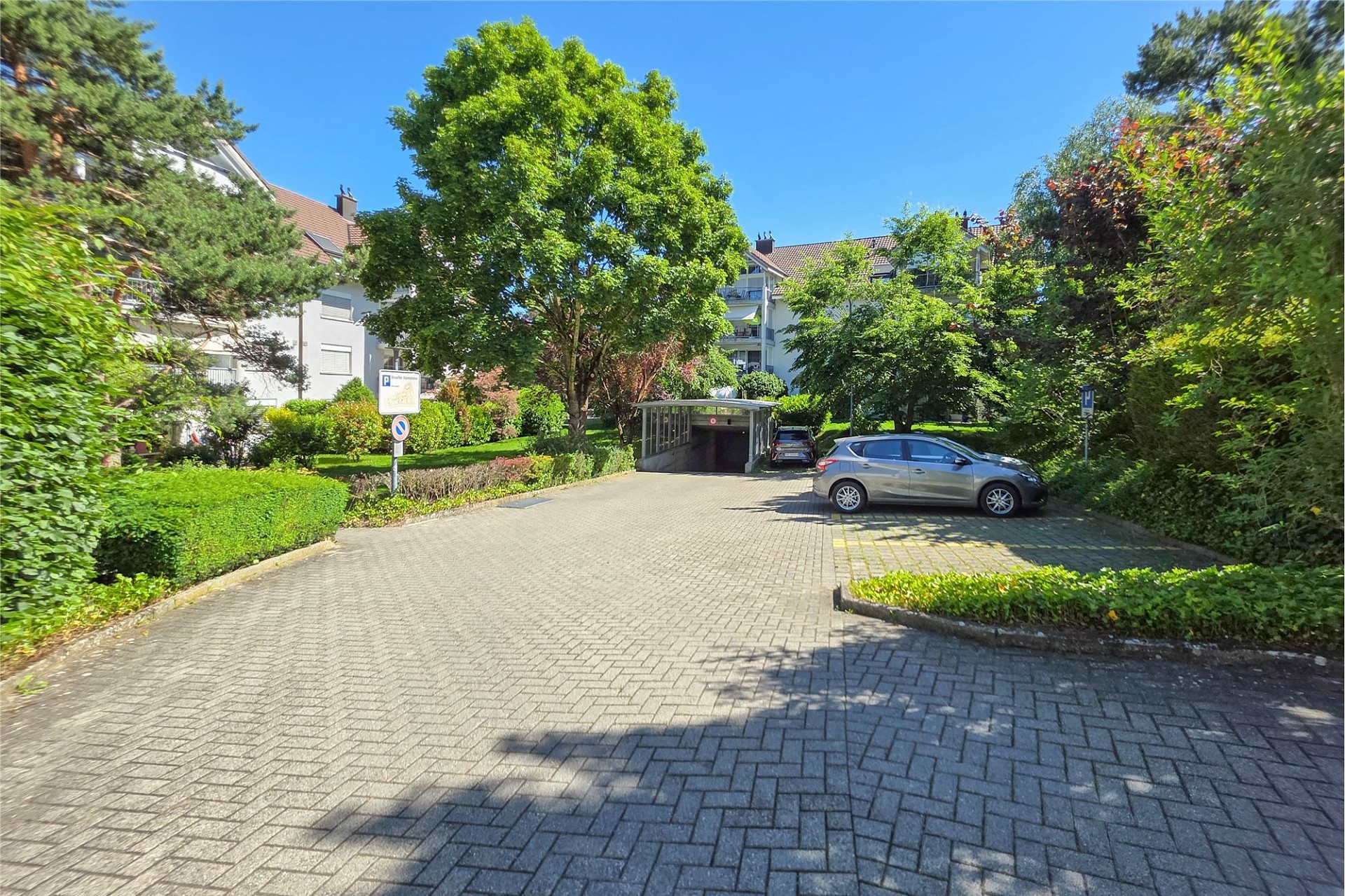 Zufahrt mit Tiefgarage in grüner Wohnanlage