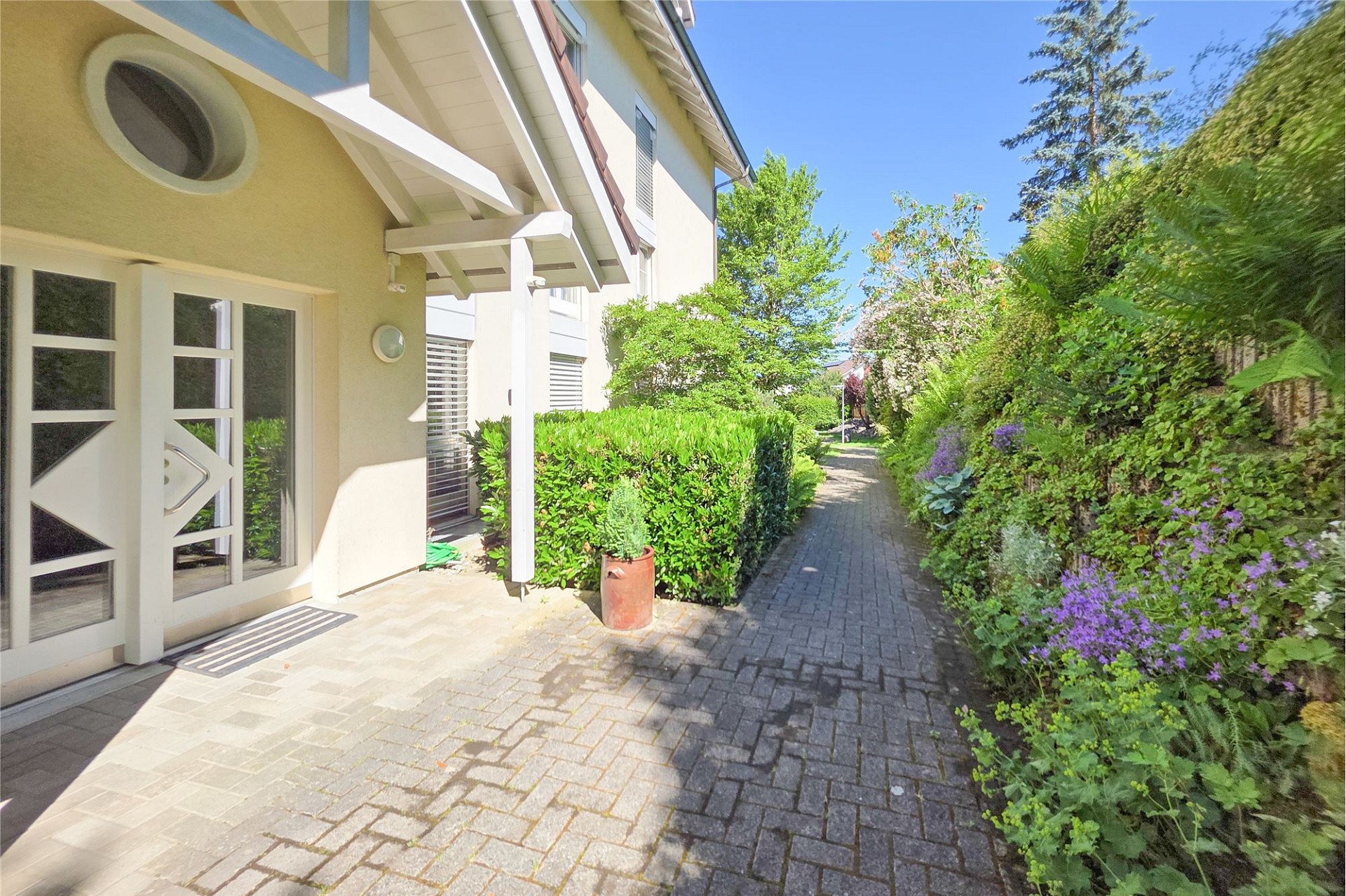 Außenansicht eines gepflegten Hauseingangs mit Gartenweg