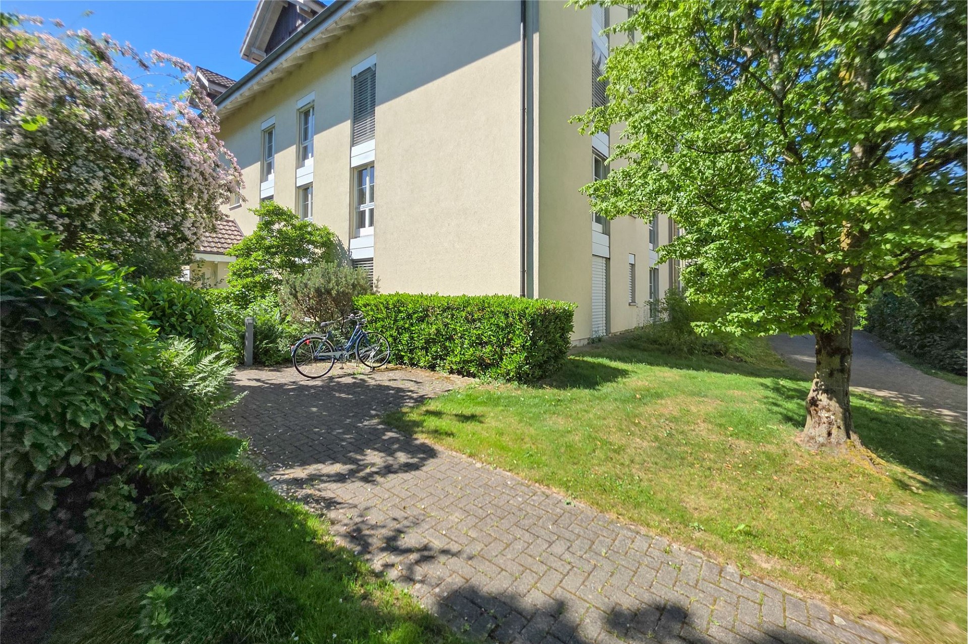 Außenansicht eines Mehrfamilienhauses mit Gartenweg