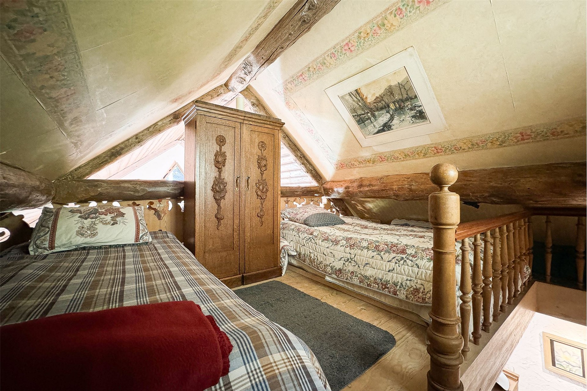 Gemütliches Dachgeschoss-Schlafzimmer mit rustikalen Holzbalken