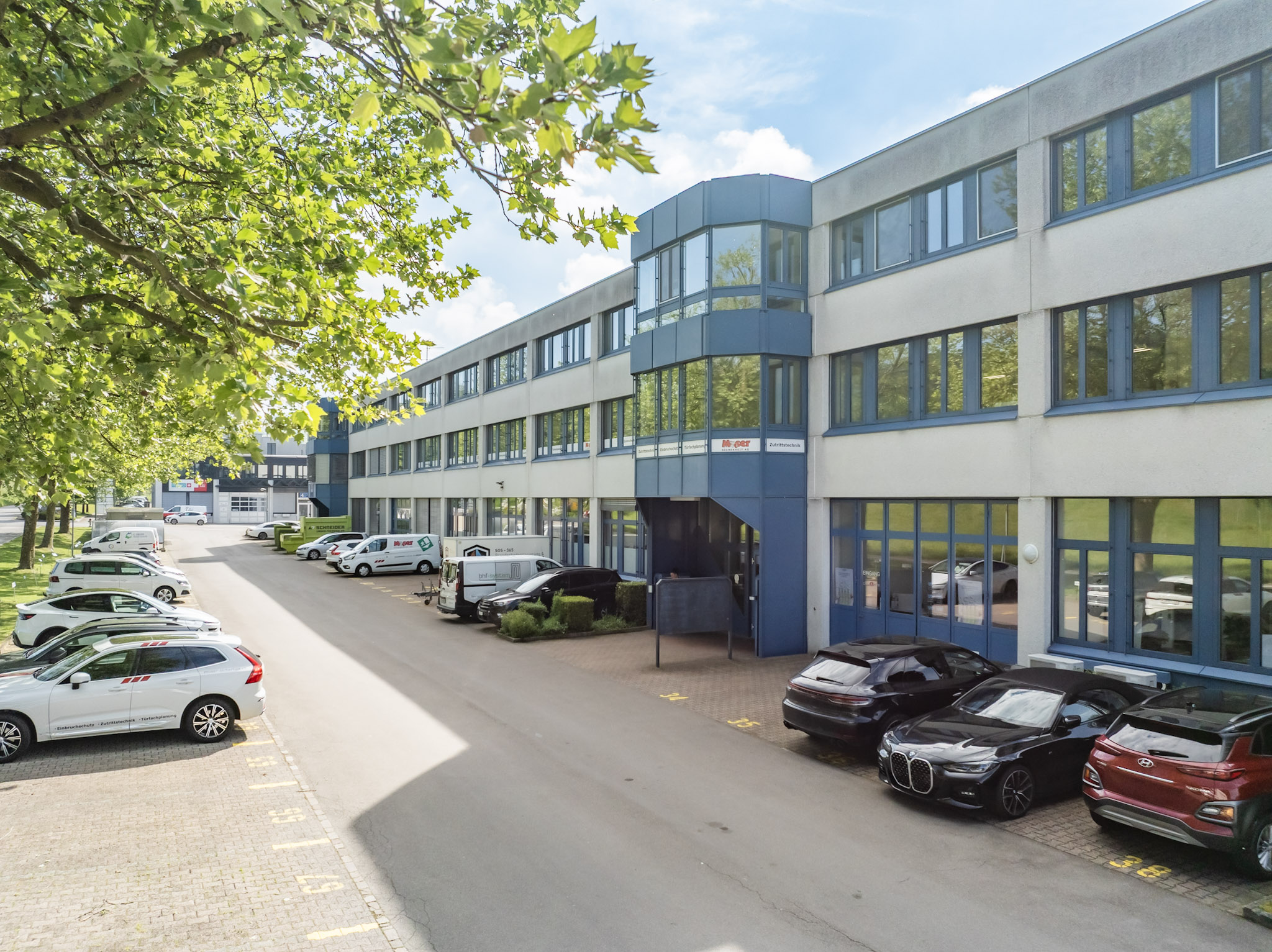 Bürogebäude mit Parkplatz und Bäumen