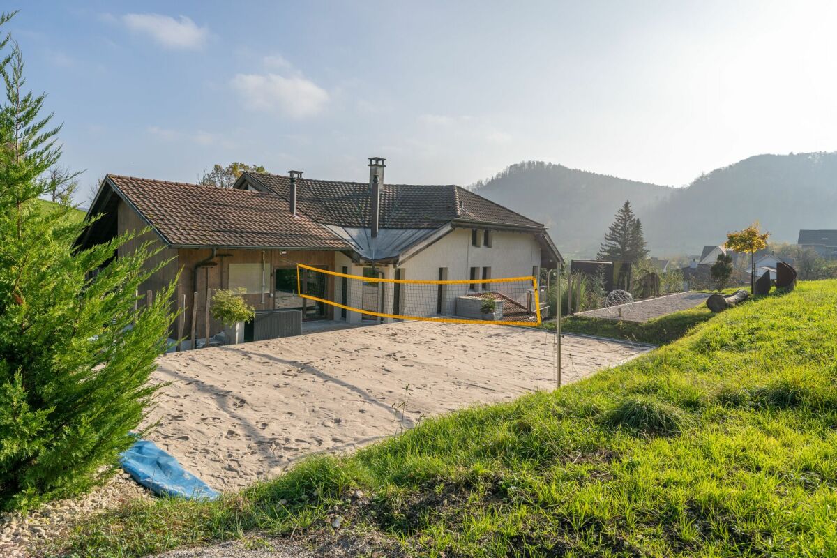 Außenansicht eines Hauses mit Garten- und Spielbereich