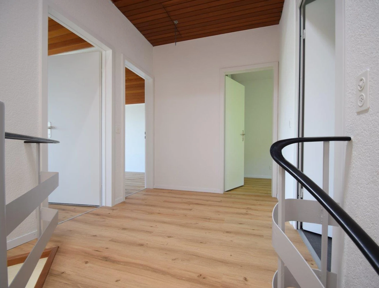 Heller Flur mit Holzdecke und Treppe