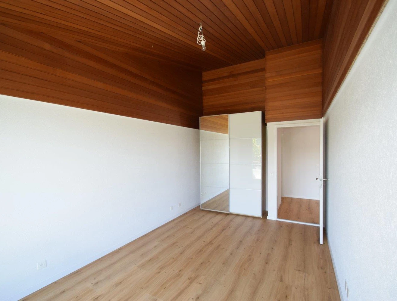 Helles Zimmer mit Holzdecke und Einbauschrank