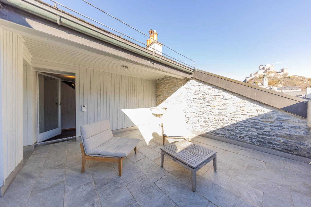 Dachterrasse mit Sitzmöbeln und Stadtblick