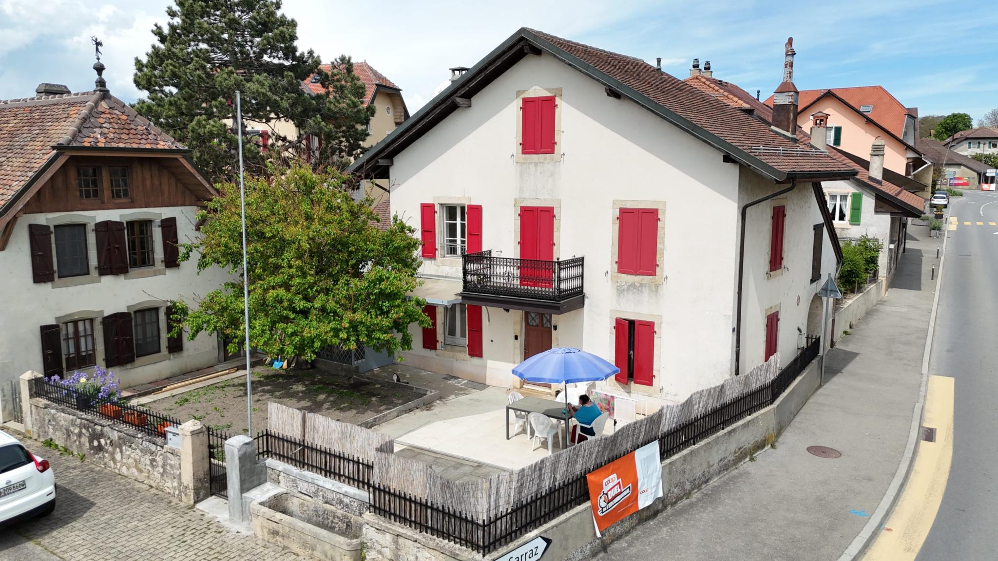 Wohnhaus mit roter Fensterläden und Terrasse