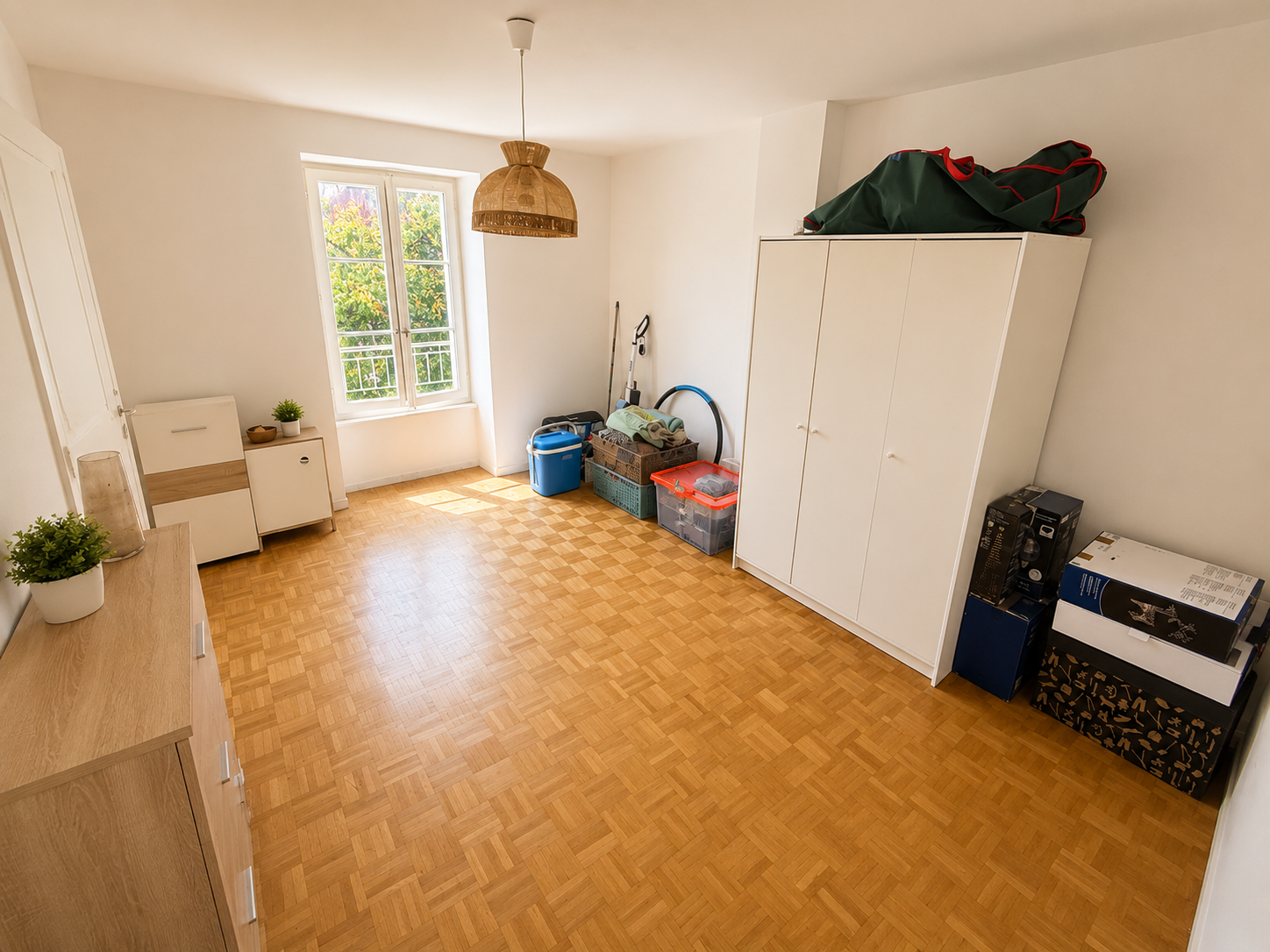 Heller leerer Raum mit Parkett, Fenster und Stauraum