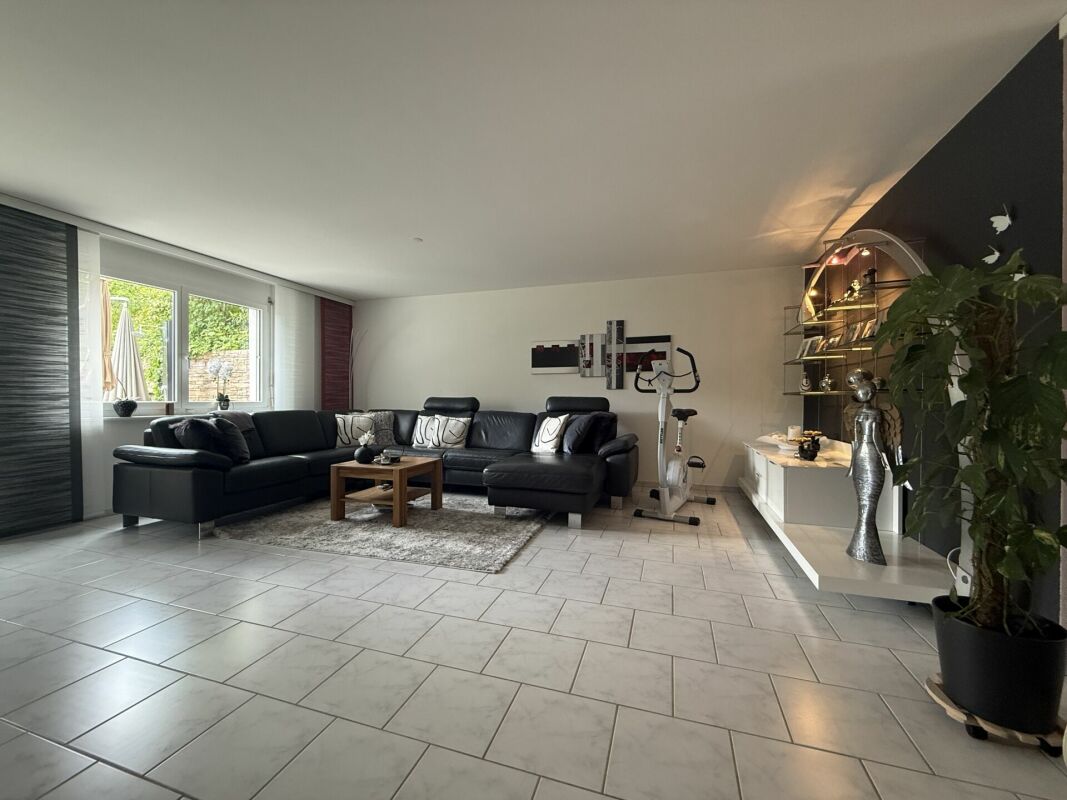 Modernes Wohnzimmer mit Ecksofa und großer Fensterfront