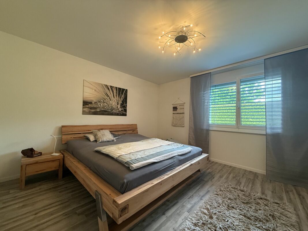 Modernes Schlafzimmer mit Holzbett und Tageslicht