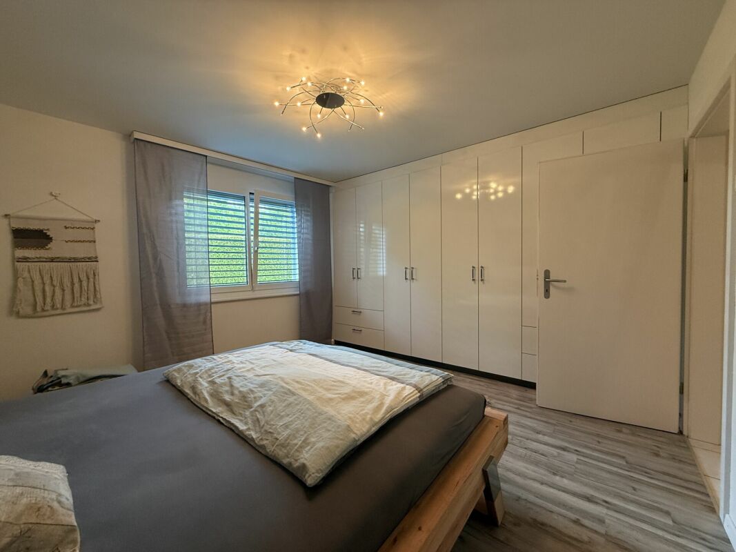 Helles Schlafzimmer mit Einbauschrank und Fenster