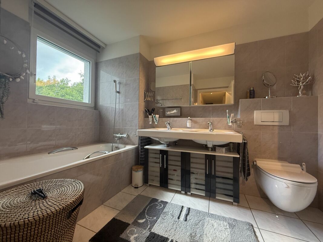 Modernes Badezimmer mit Badewanne, Doppelwaschtisch und WC