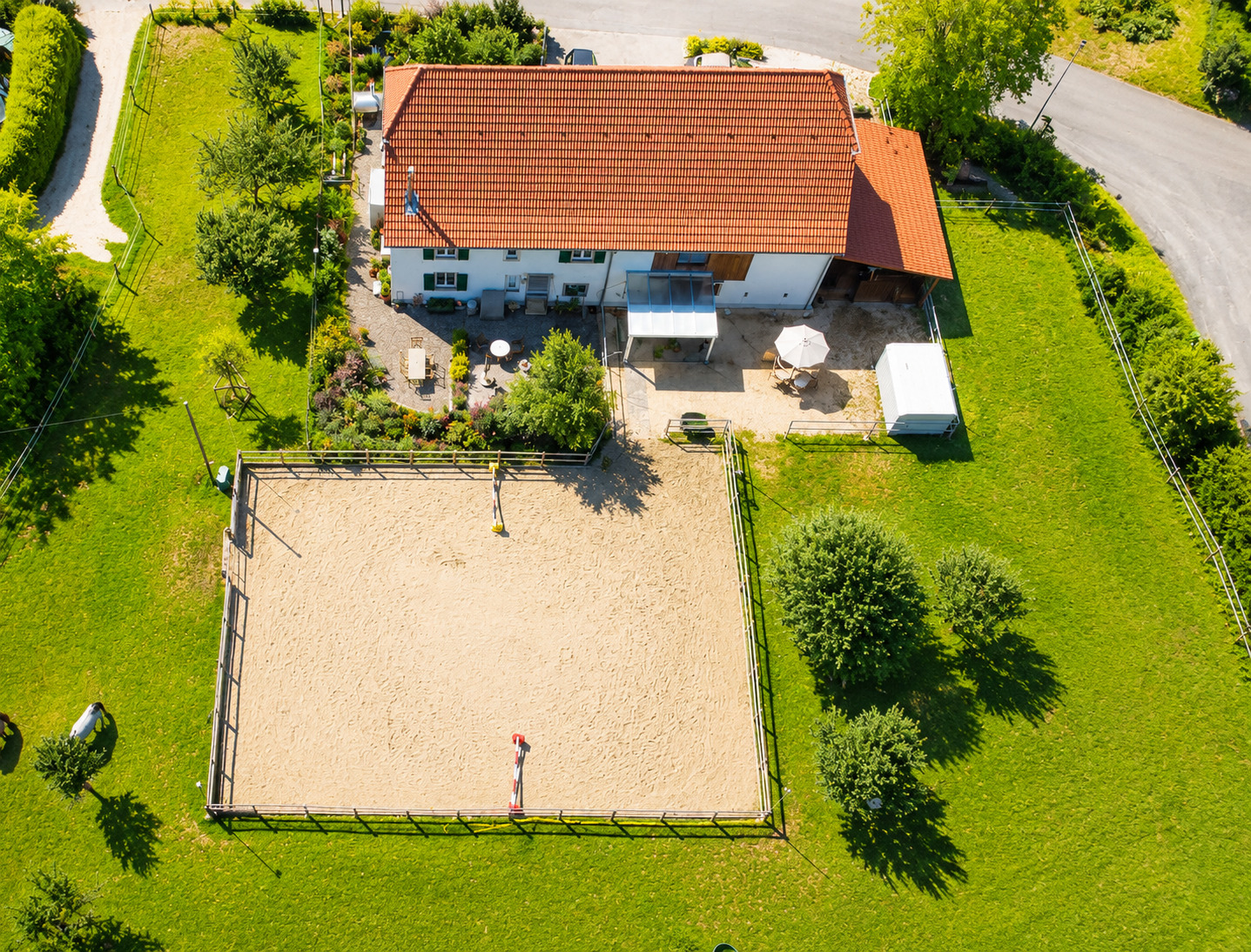 Luftaufnahme eines ländlichen Anwesens mit Reitplatz