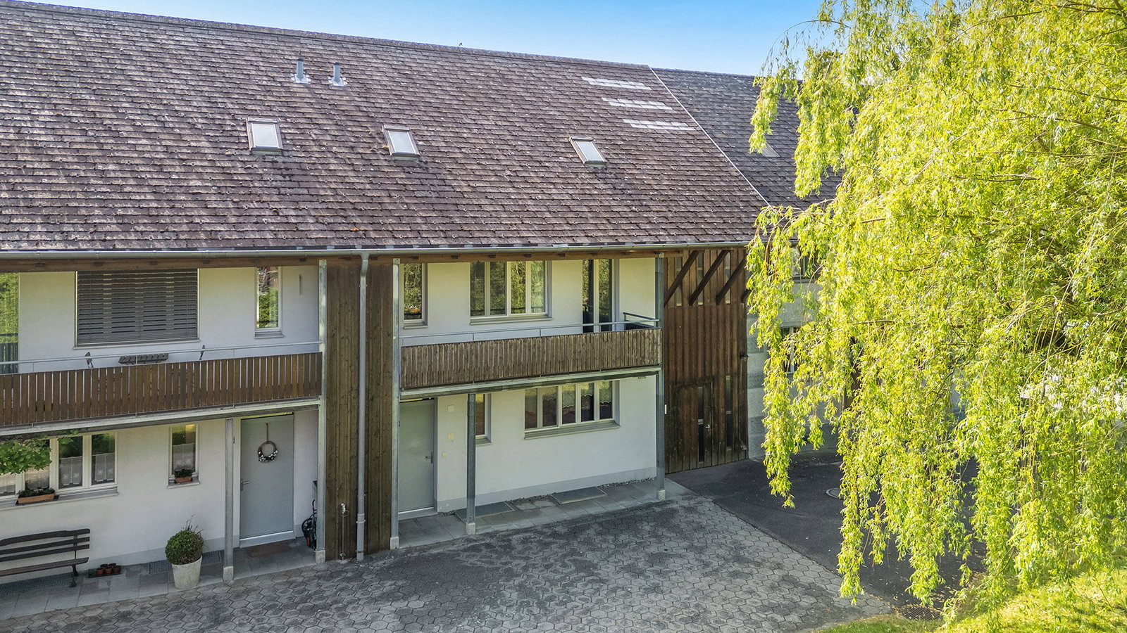 Außenansicht eines Wohngebäudes mit Balkon und steilem Dach