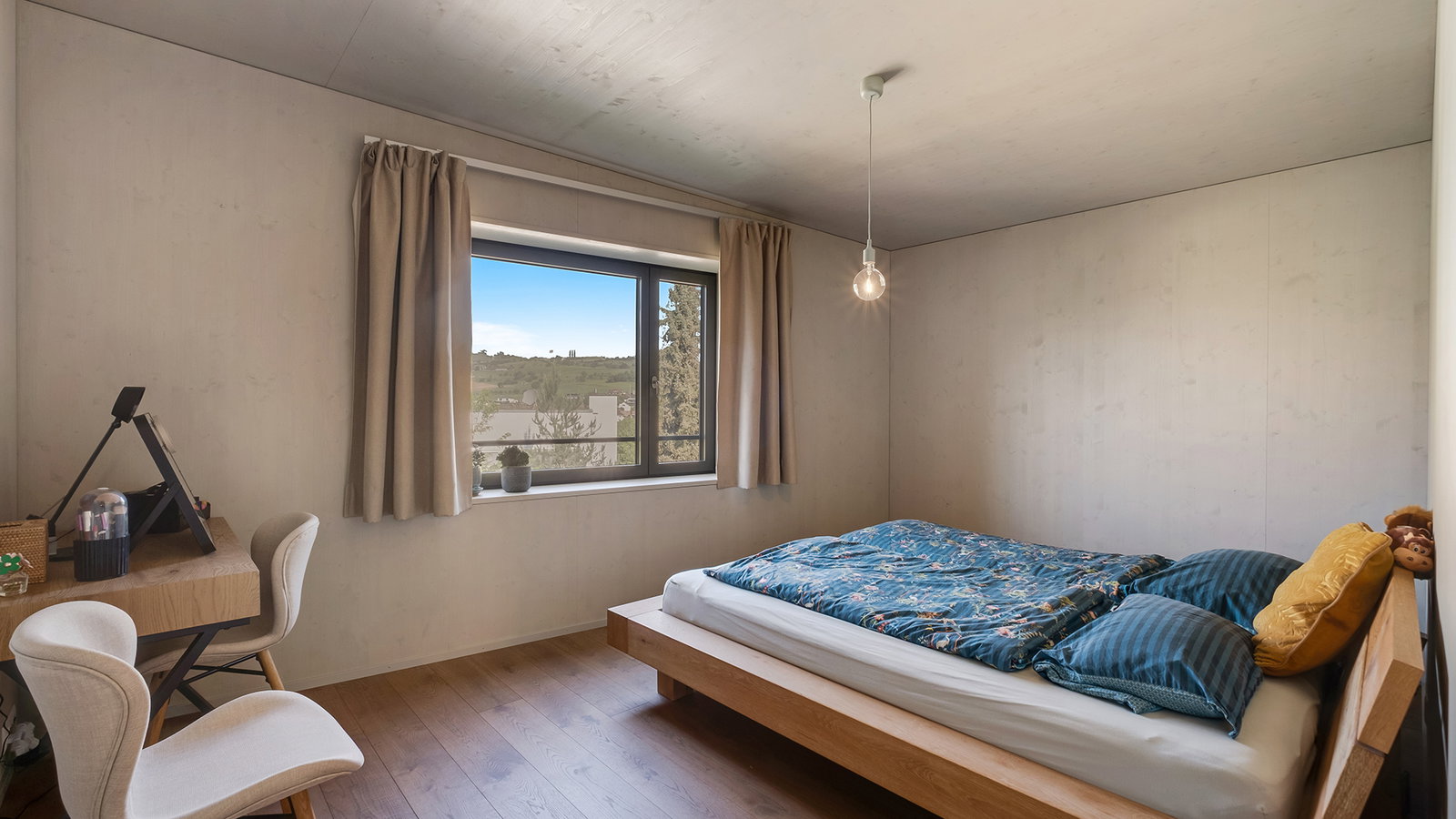Schlichtes Schlafzimmer mit Bett und Fensterblick