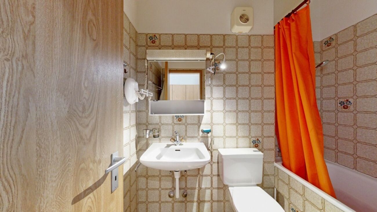 Kleines Badezimmer mit Retro-Fliesen und Badewanne