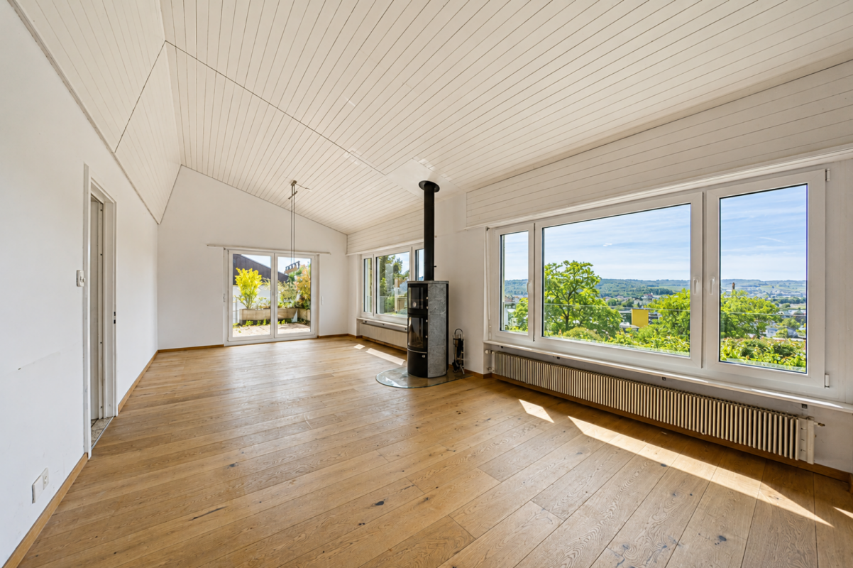 Heller Wohnraum mit Holzfußboden und großen Fenstern