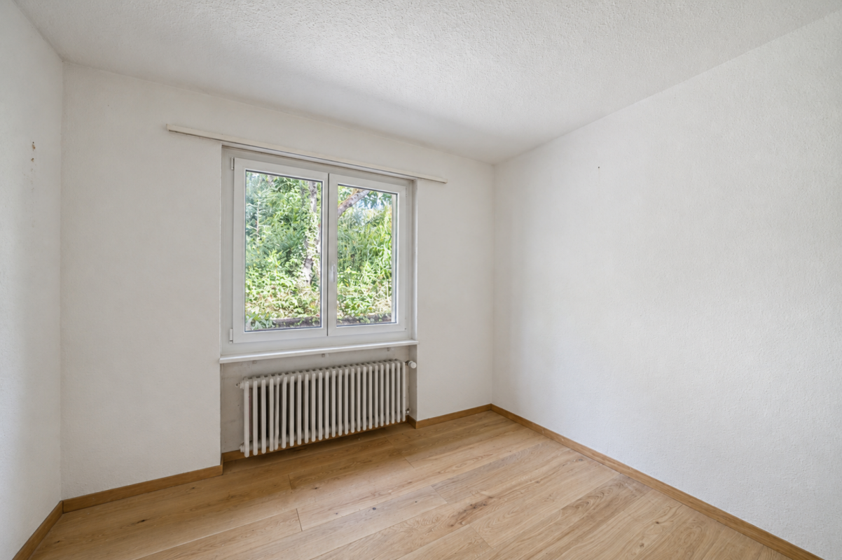 Leerer heller Raum mit Fenster und Heizkörper