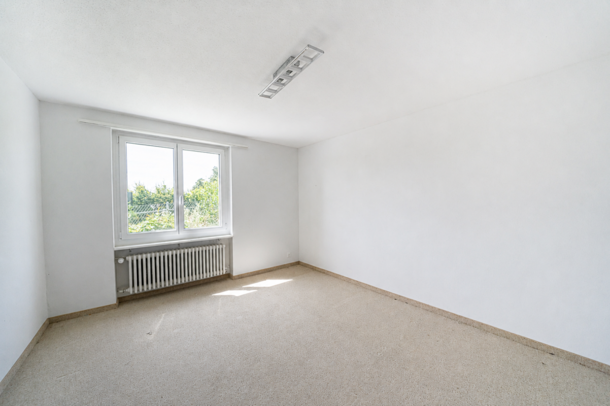 Leerer heller Raum mit Fenster und Heizkörper
