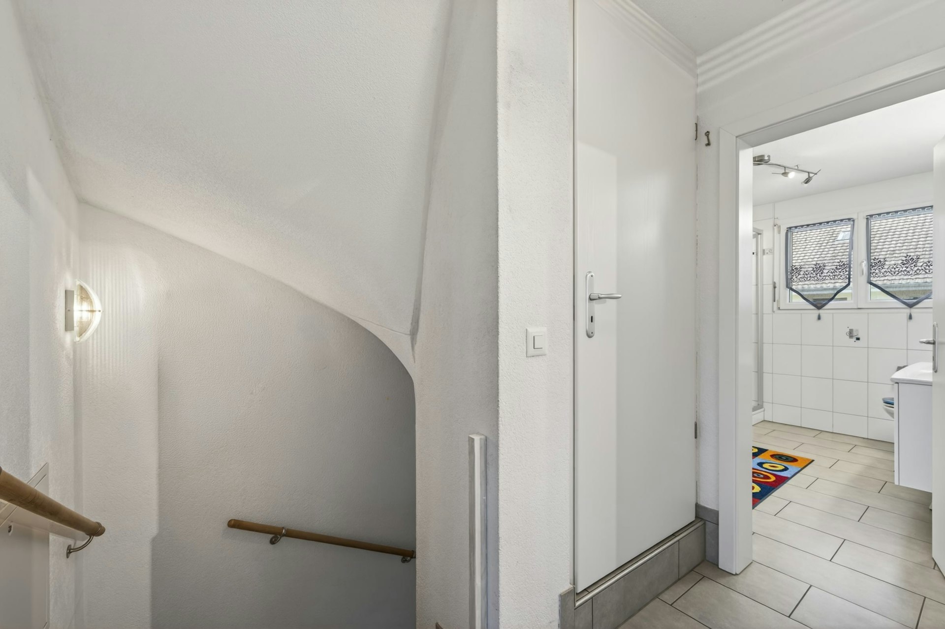 Heller Treppenflur mit Blick ins Badezimmer