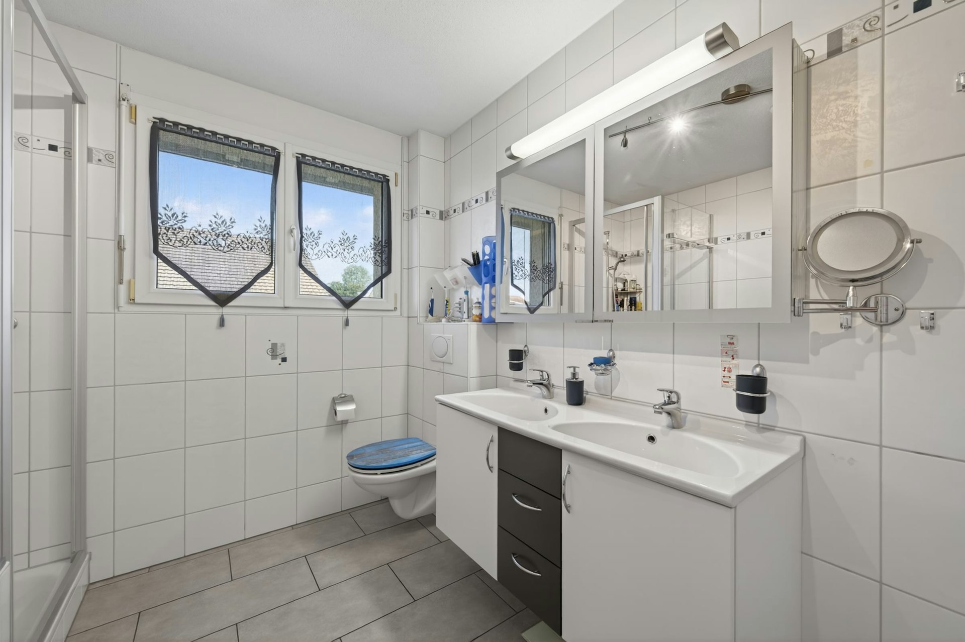 Helles Badezimmer mit Doppelwaschtisch und Dusche