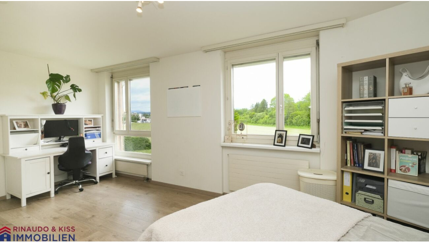 Helles Schlafzimmer mit Arbeitsplatz und Blick ins Grüne