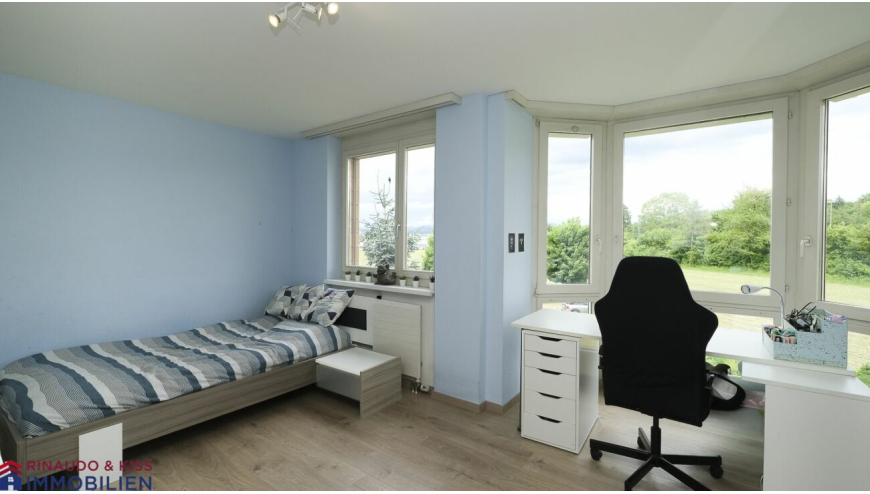 Schlafzimmer mit Arbeitsplatz und großem Fensterblick