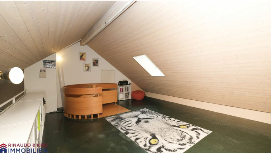 Dachgeschossraum mit Holzverkleidung und Teppich