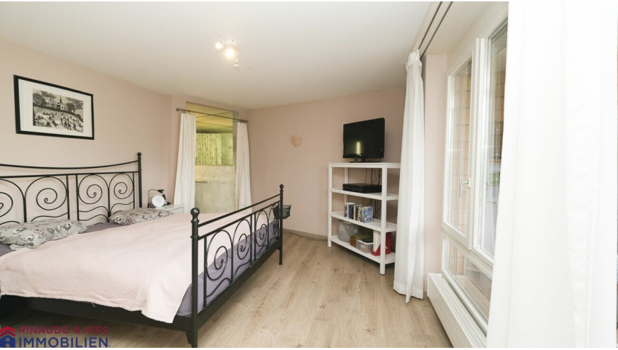 Helles Schlafzimmer mit Metallbett und Fenstern